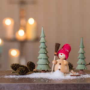 Schneemann mit Besen im Wald