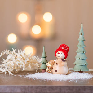 Schneemann mit Vogel im Wald