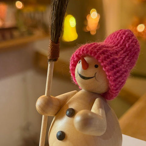 Schneemann mit Besen im Wald