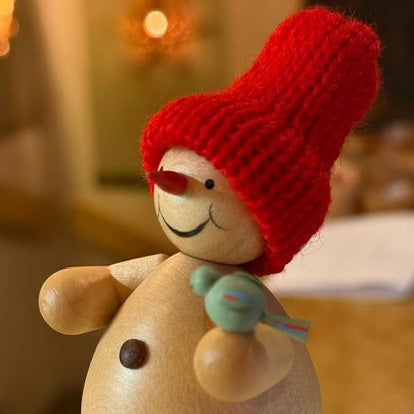 Schneemann mit Vogel im Wald